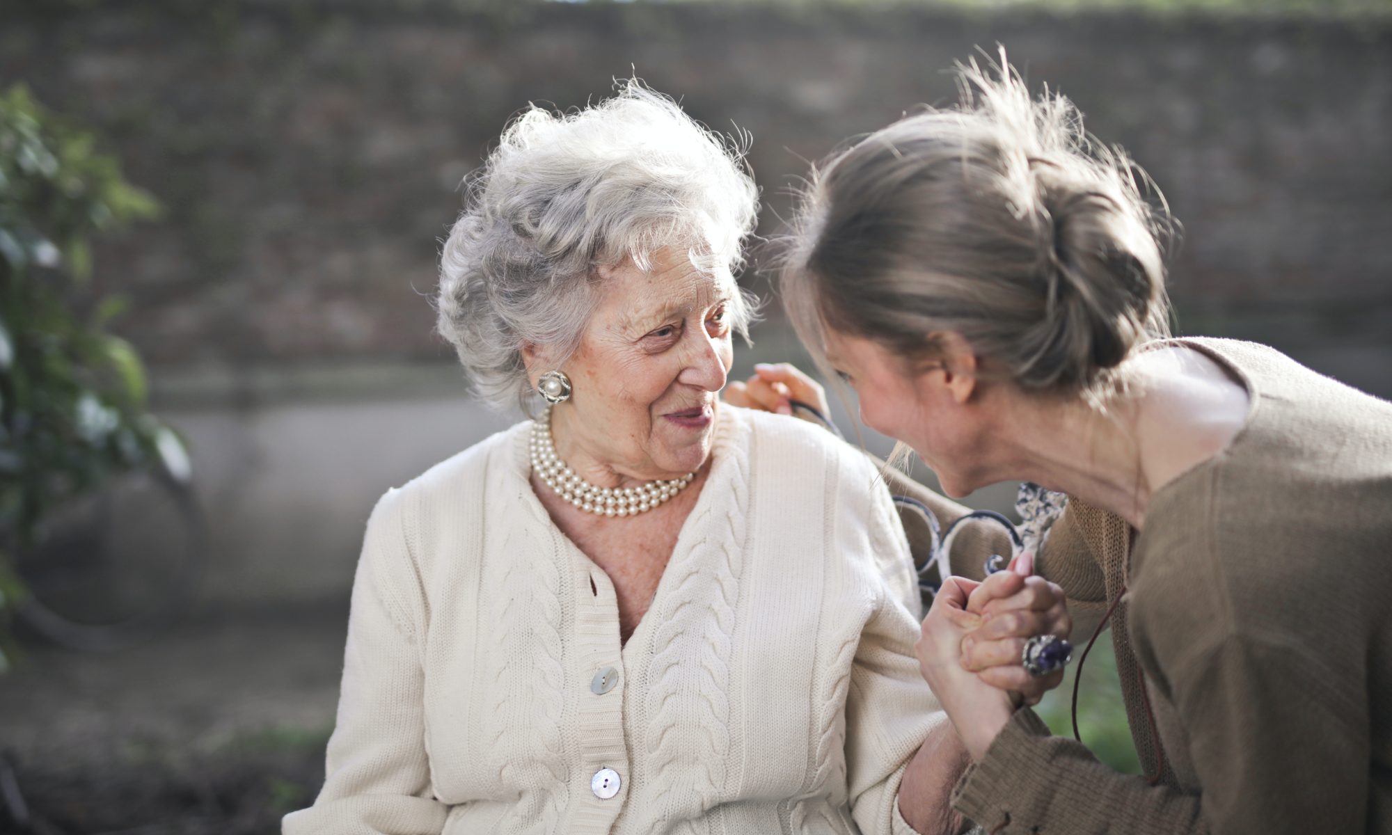 Elderly woman sitting with younger woman